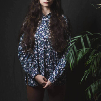 Photo by https://www.finnsquare.com/ photo of a girl with long brown hair wearing a flower print shirt looking at the camera